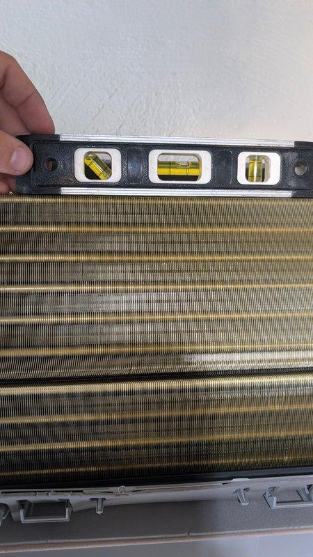 Responded to service call for newly installed mini split system experiencing water leakage. Upon arrival, discovered indoor unit was not properly leveled, causing condensate drainage issues. Used torpedo level to verify improper pitch on both the air handler and evaporator coil assembly. Adjusted mounting bracket and repositioned unit to achieve correct horizontal alignment, ensuring proper condensate flow to drain line. Verified level positioning across filter compartment and finned coil section. Tested system operation and confirmed water now draining properly without leakage.