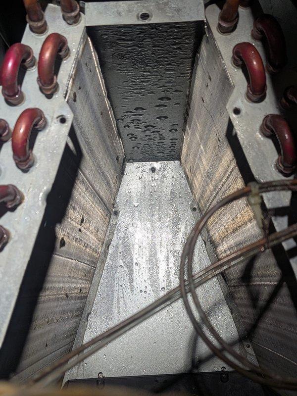 Responded to water leak originating from 16-year-old furnace in basement. Upon arrival, found significant flooding throughout basement area with standing water covering floor. Inspection revealed moisture and condensation accumulation within furnace cabinet compartment, with water droplets visible on interior metal walls and base. Identified leak source as condensate drainage issue from HVAC unit. Documented conditions with photos showing water damage extent and furnace interior moisture buildup. Customer advised of findings and recommended follow-up for proper drainage repair and water extraction services to prevent further damage to basement and equipment.
