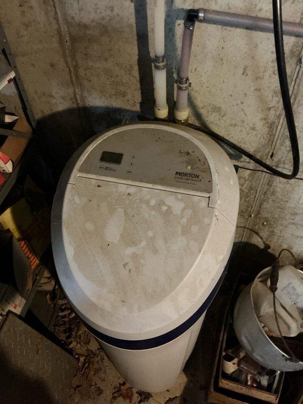 Responded to service call for non-functioning Morton water softener system, approximately 4 years old. Upon arrival, performed diagnostic assessment of the unit including inspection of the digital control panel, plumbing connections, and electrical supply. Examined the system's copper and PVC inlet/outlet piping, verified proper connections to the main water line, and checked the pre-filtration blue housing mounted on the concrete block wall. Restored system to proper working condition and verified operational status before departure.