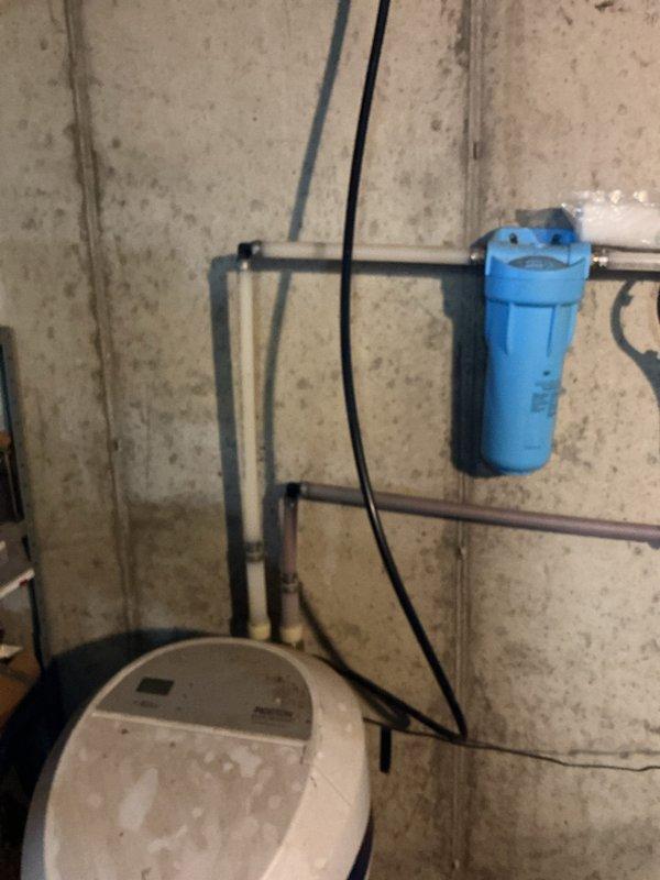 Responded to service call for non-functioning Morton water softener system, approximately 4 years old. Upon arrival, performed diagnostic assessment of the unit including inspection of the digital control panel, plumbing connections, and electrical supply. Examined the system's copper and PVC inlet/outlet piping, verified proper connections to the main water line, and checked the pre-filtration blue housing mounted on the concrete block wall. Restored system to proper working condition and verified operational status before departure.