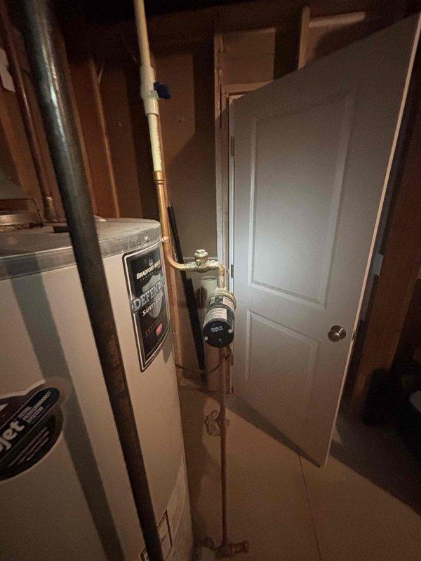 Responded to no hot water call at single-family residence with active leak from original 16-year-old Bradford 65-gallon standard tank water heater. Upon arrival, confirmed unit was actively leaking and had reached end of serviceable life, resulting in complete loss of hot water to home with 3 showers and large soaker tub. Documented existing equipment and utility room conditions with photos showing water heater, copper supply lines, pressure tank, and mechanical room layout for customer records and replacement planning recommendations.