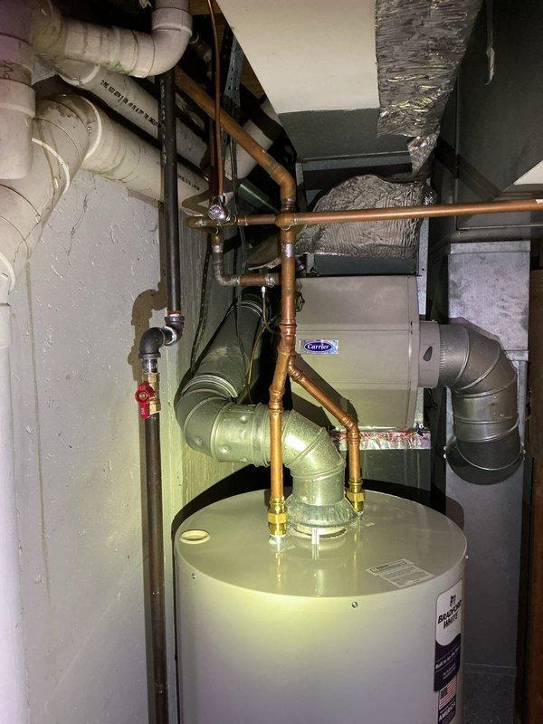 Successfully installed a 40-gallon natural gas Bradford White short water heater in basement utility room. Completed all copper piping connections with brass fittings, installed red-handled isolation valve on supply line, and ensured proper venting and gas line connections per manufacturer specifications and local code requirements.