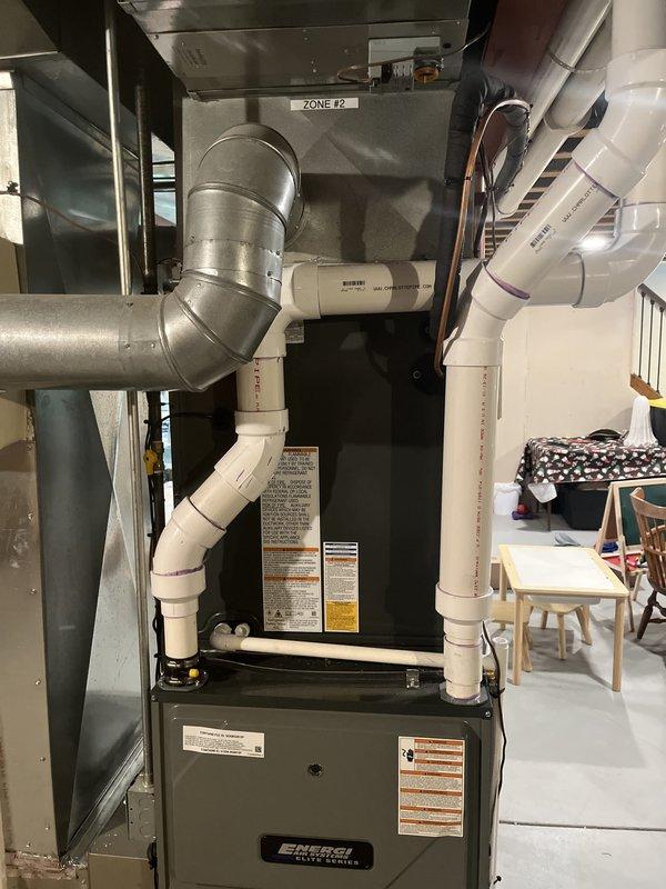 Completed full furnace installation including black EMERGI brand heating unit with proper mounting and connection to existing ductwork system. Installed comprehensive PVC venting system with vertical exhaust piping, refrigerant line connections, and integration with multi-zone HVAC configuration including Zone #2 ductwork. Verified all safety labels, specifications, and warning indicators properly displayed on unit, ensured proper clearances, and confirmed system operational with existing outdoor condenser unit.