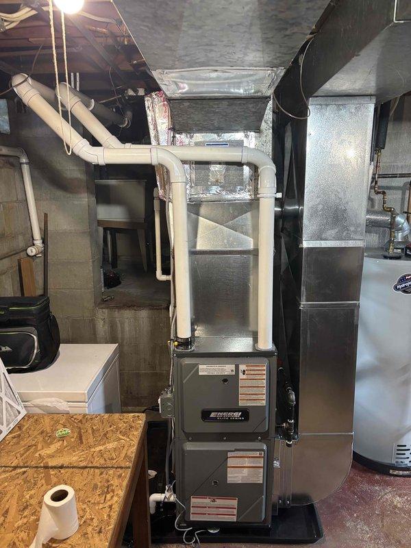 Completed full furnace installation in basement mechanical room. Installed new high-efficiency furnace unit on platform base with proper clearances from concrete block walls and adjacent water heater. Connected unit to existing ductwork system including metallic rectangular supply ducts and return air pathways. Installed white PVC venting system extending vertically from furnace top to approved termination point. Mounted evaporator coil unit above furnace with proper drain pan installation. Connected all necessary gas lines, electrical connections, and condensate drainage per manufacturer specifications and local code requirements. Verified proper airflow, tested all safety controls, and confirmed system operation. Processed Michigan Saves financing documentation through electronic signature platform for project completion.