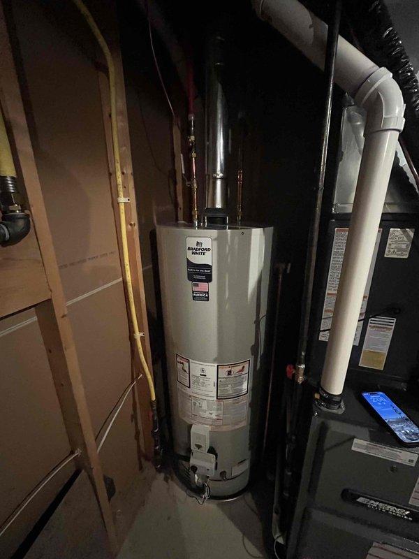 Completed full HVAC system installation in basement utility area including new furnace with humidifier attachment, air conditioning system, and Bradford White water heater. Installed all associated ductwork, copper piping, PVC condensate lines, gas connections, and flue venting per manufacturer specifications. All equipment tested and operational upon completion with digital controls programmed and verified.
