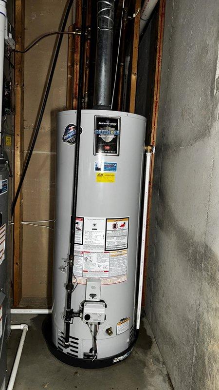 Installed a Bradford White 50-gallon natural gas water heater (model B2SU07S12N) in residential basement. Connected copper supply and distribution lines, installed black vent piping, and completed electrical connections to control panel. Unit tested and verified operational with all safety labels and specifications visible per manufacturer requirements.