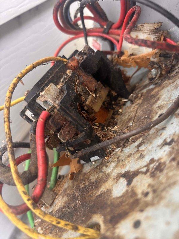 # AC Annual Cooling Maintenance - 26-Year-Old Heil System

Completed annual cooling maintenance on a 26-year-old Heil air conditioning system. Upon inspection, discovered severe corrosion and rust throughout the electrical housing and contactor assembly, indicating long-term moisture exposure and environmental deterioration. The metal casing showed extensive pitting and orange-brown discoloration with significant rust accumulation around wire connection points. Electrical components including the contactor displayed worn wire insulation on red, yellow, black, and green conductors. Debris and organic material had accumulated around electrical connections within the corroded housing.

Documented the advanced deterioration of the compressor unit and electrical components through photographs. The system's age and extensive corrosion present significant reliability and safety concerns. Strongly recommend replacement of the outdoor unit due to the compromised structural integrity of the elec
