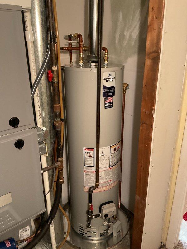 Installed a 40-gallon tall tank Bradford White natural draft natural gas water heater in basement utility room. Connected copper supply lines with shutoff valves, installed metallic exhaust flue venting system with proper draft configuration, and established all gas line connections to manufacturer specifications. Installation includes 6-year parts and 6-year labor warranty coverage.