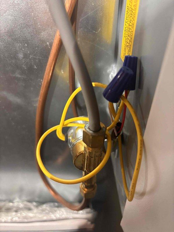 Completed annual heating maintenance visit on 2014 EnergiAir system with humidifier. Inspected electrical connections, service valves, and refrigerant lines; all components found in proper working condition. Documented system configuration with photos showing brass service ports, wire connections with proper wire nut terminations, and refrigerant line routing for service records.