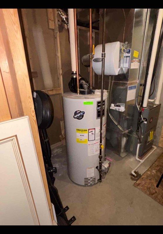 Responded to callback for slow-draining toilet issue. Upon arrival, inspected plumbing system and documented water heater condition showing significant corrosion on burner assembly and discoloration on metal components. Photographed mechanical room setup including water heater, furnace unit, and associated copper and PEX piping connections for service records. Trip charge waived per customer service protocol.
