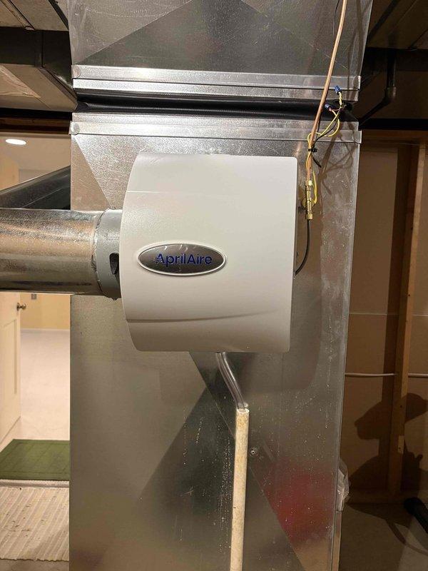 Completed installation of AprilAire manual humidifier unit on existing HVAC ductwork system. Mounted humidifier to main supply plenum, connected water supply line via copper piping, and integrated unit with ductwork to provide whole-home humidity control. System tested and operational upon completion.
