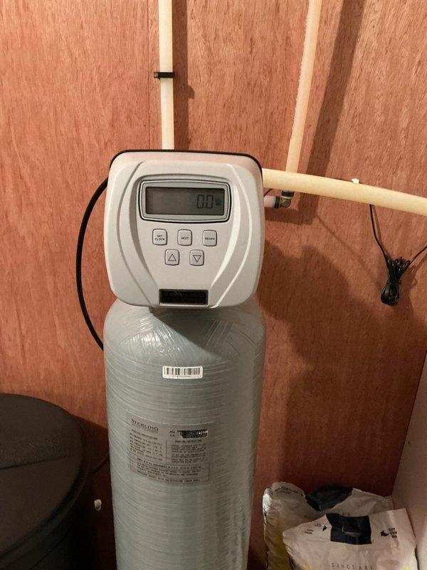 Responded to continuous drain issue on Sterling water softener system. Inspected digital control head displaying zero reading and examined PVC supply/drain line configuration. System evaluated for proper cycling and drain flow control to resolve continuous drainage problem.