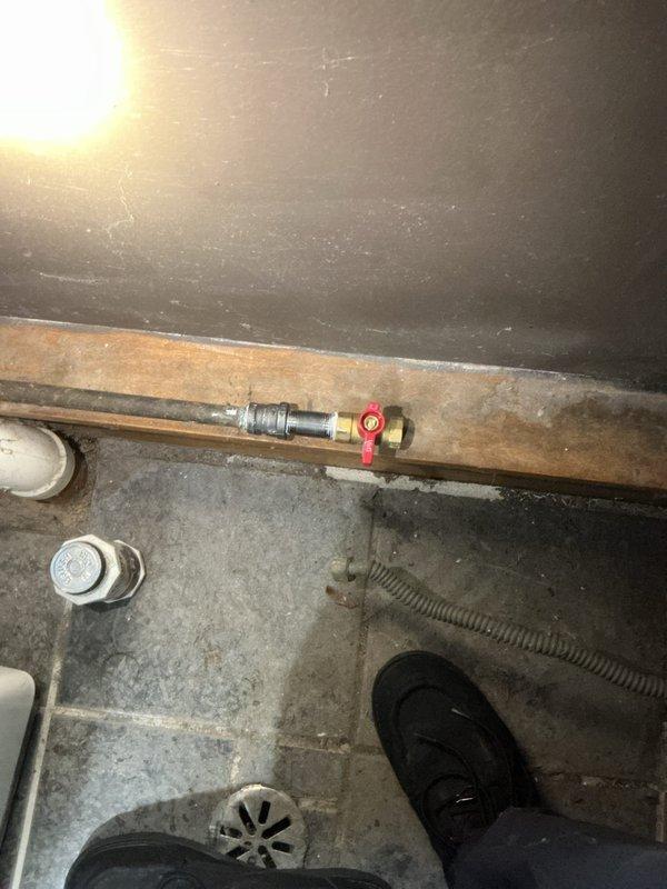 Completed installation of gas shutoff valve and appliance connection to existing gas line. Inspected water heater area and confirmed proper placement of copper piping with brass fittings and red-handled shutoff valve. All connections secured and tested for safe operation, with photographic documentation of completed work in utility space.
