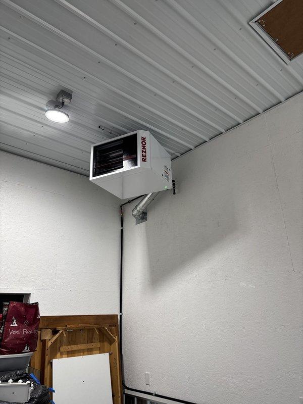 Installed new Reznor unit heater in commercial/warehouse space, mounting unit high on wall near ceiling corner. Completed electrical connections via conduit, verified proper operation of horizontal louver discharge system, and ensured heating unit functions correctly for the space.