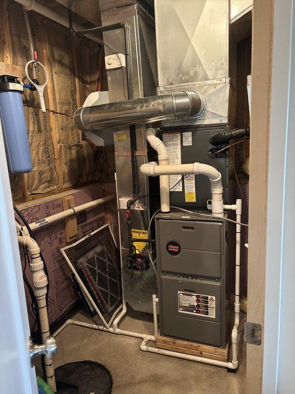 Completed full AC replacement at residential property. Removed existing air conditioning system and installed new Ruud outdoor condensing unit on concrete pad with proper electrical connections and refrigerant line sets. Installed matching indoor air handler components integrated with existing furnace system in basement mechanical room. Ran new PVC condensate drain lines from indoor unit with proper pitch and termination. Verified all electrical connections, refrigerant charge levels, and system pressures meet manufacturer specifications. Tested complete system operation including cooling cycle, airflow, and thermostat communication. All equipment properly secured, leveled, and positioned for optimal performance and serviceability.