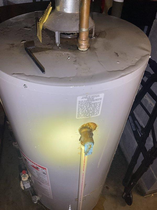 Responded to service call for leaking water heater estimated to be 15-20 years old. Performed comprehensive assessment of existing unit located in basement utility area, documenting condition through photographic evidence. Observed visible water damage and yellow staining on lower portion of tank exterior, indicating active leak from aging equipment. Evaluated all plumbing connections including copper supply lines, brass fittings, pressure relief valve, and drain valve assembly. Assessed surrounding infrastructure including PVC drainage, galvanized ductwork, and concrete block wall clearances. Provided detailed estimate for complete water heater replacement due to tank failure and age of existing unit beyond serviceable lifespan.