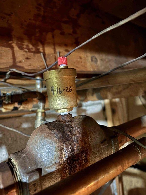 Responded to service call for 24-year-old Utica boiler experiencing small leak identified during home inspection prior to property sale. Upon arrival, inspected boiler system and located source of leak at corroded piping section beneath brass filter housing. Documented extensive rust and oxidation on affected pipe fitting, indicating prolonged moisture exposure and deterioration of ferrous metal components. Assessed overall condition of heating system and identified necessary repairs per home inspector's requirements to facilitate property closing. Photographed corroded areas and affected components showing compromised pipe integrity with heavy rust buildup on connections below filter assembly dated 9-16-26. Provided homeowner with detailed findings and repair recommendations to address leak and corrosion issues for real estate transaction completion.