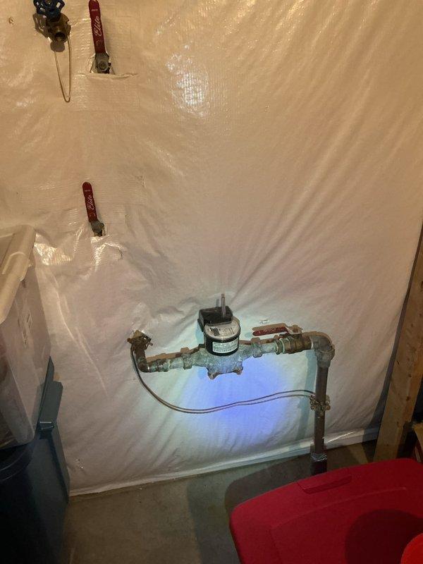 # Water Leak Service Completed

Responded to water leak investigation and performed comprehensive plumbing system inspection. Upon arrival, identified corroded copper piping with significant greenish-white patina buildup indicating long-term moisture exposure and potential leak source. Inspected horizontal and vertical pipe runs along with associated fittings and joints for integrity issues.

Documented existing plumbing configuration including water pump/valve controller assembly with cylindrical motor component and control housing. Assessed condition of copper pipe connections, elbow joints, and various fittings throughout the system. Noted advanced corrosion on horizontal pipe sections requiring attention.

Established containment area with protective plastic sheeting to prevent water damage during inspection and repair work. Evaluated electronic control device and associated wiring for proper operation. Identified compromised pipe sections showing deterioration and patina formation