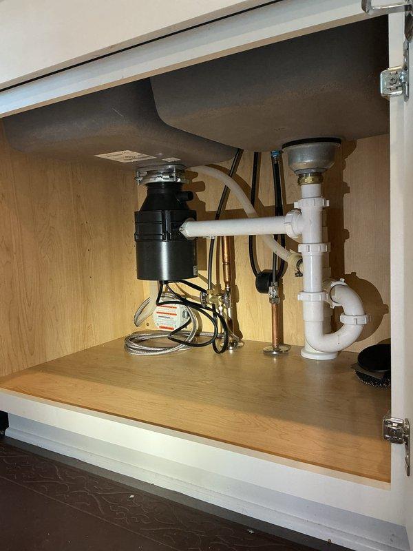 Responded to service call for leaking garbage disposal unit. Upon inspection, identified active leak at disposal mounting assembly beneath kitchen sink. Removed and reinstalled disposal unit with new mounting flange and gasket to eliminate leak. Tested unit operation and verified all connections were secure and leak-free upon completion.