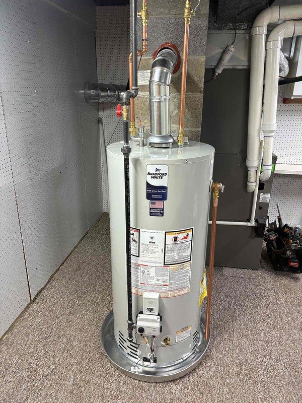Successfully installed a 40-gallon Bradford White natural gas water heater in the basement utility room. Completed all plumbing connections using copper pipes with brass fittings and shut-off valves, installed proper venting with metallic exhaust pipe, and ensured all safety labels and specifications were visible and compliant. Unit was secured on appropriate base platform with all connections tested and operational.