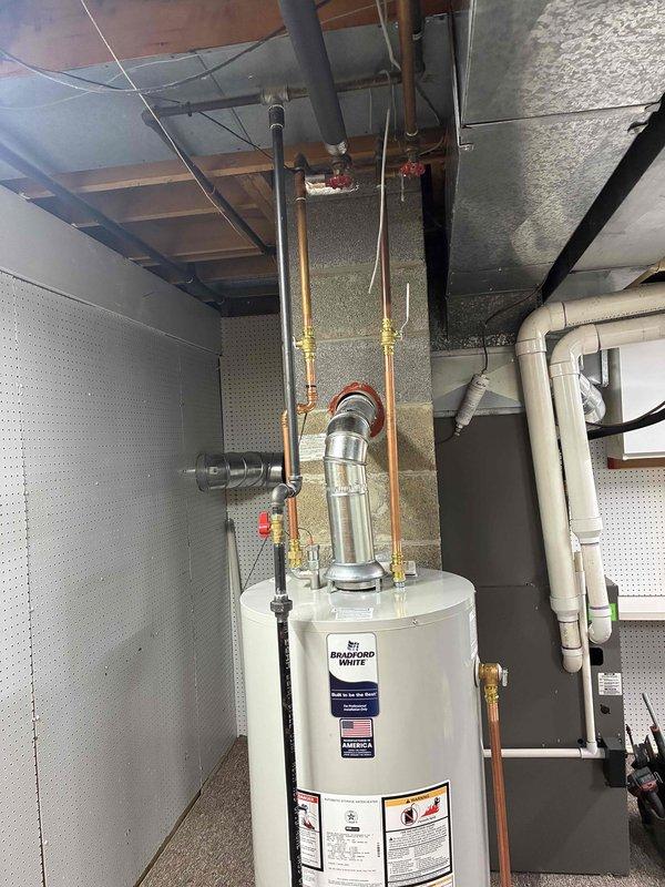 Successfully installed a 40-gallon Bradford White natural gas water heater in the basement utility room. Completed all plumbing connections using copper pipes with brass fittings and shut-off valves, installed proper venting with metallic exhaust pipe, and ensured all safety labels and specifications were visible and compliant. Unit was secured on appropriate base platform with all connections tested and operational.