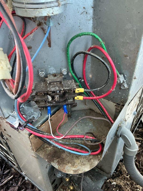# Annual Cooling Maintenance Completed

Performed comprehensive annual cooling maintenance on 20-year-old ARCO air conditioning system. Conducted thorough inspection of outdoor condensing unit, including electrical connections, capacitor, and internal components. 

Discovered significant debris accumulation throughout electrical junction box and unit interior, including dried grass, leaves, and organic matter that had collected around wire connections and terminal blocks. Cleaned all electrical connection points and removed debris from equipment housing to prevent potential electrical failures and ensure safe operation.

Inspected all electrical wiring and connections, noting presence of multiple colored conductors (red, blue, black, green, yellow) with wire connectors. Evaluated condition of terminal block and connection panel, observing age-related corrosion and weathering on metal surfaces. Checked capacitor mounting and security.

Documented equipment condition with photographic ev