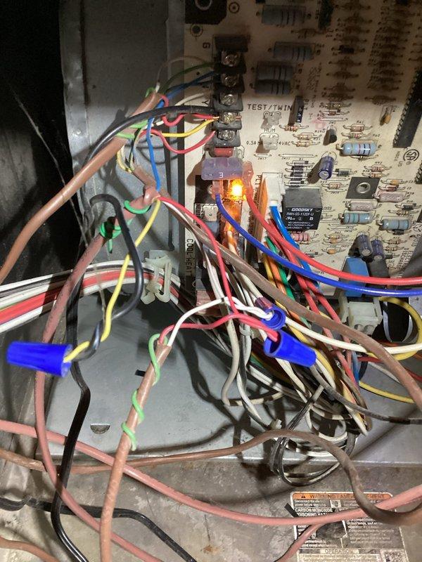 Completed annual heating and cooling maintenance on EnergiAir system under 3-year warranty coverage extending through June 2028. Performed comprehensive tune-up including inspection of control board with TEST/TWIN functionality, verified proper operation of all electrical connections and terminal blocks, and confirmed illuminated orange LED indicator showing active system status. Inspected outdoor temperature sensor mounted on exterior wall, verified wiring connections at blue terminal block with brown, white, and red-striped conductors intact and secure. Documented system components and wiring configuration through photographic records for warranty compliance and future service reference.