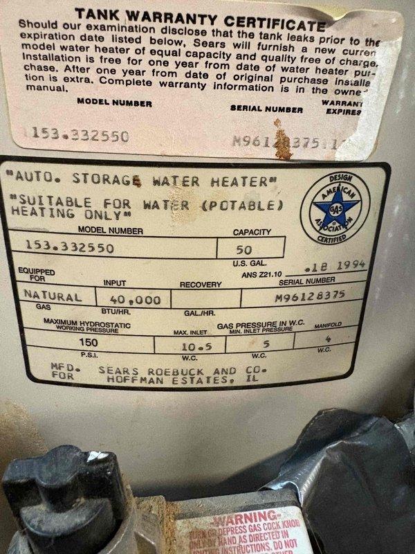 Responded to emergency water heater replacement estimate for a leaking 50-gallon natural gas Sears unit (Model 153.332550) manufactured in 1994. Upon inspection, confirmed active leak requiring immediate replacement due to age and deterioration of the tank, with visible corrosion noted on warranty plate and unit showing nearly 30 years of service life exceeding typical operational lifespan. Documented existing installation configuration including copper supply line connections, pressure relief valve assembly, and current placement on concrete pad in basement utility area, and provided comprehensive estimate for new water heater installation.