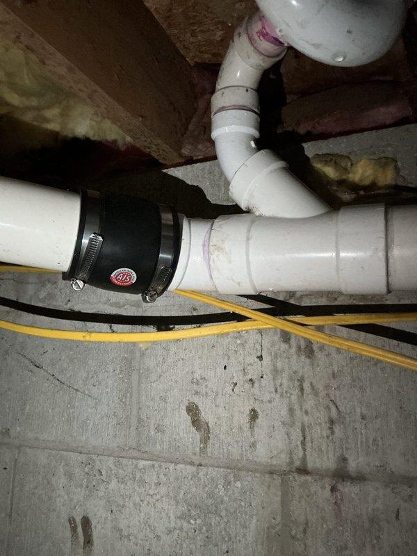 Responded to drainage system issue and successfully repaired broken drain pipe section in basement crawlspace area. Replaced damaged PVC pipe segment using black rubber Fernco coupling with stainless steel hose clamps to ensure watertight seal. Tested system to verify proper drainage flow and confirmed no leaks at repair connection points.