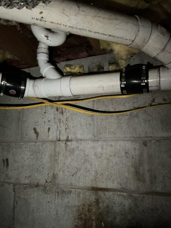 Responded to drainage system issue and successfully repaired broken drain pipe section in basement crawlspace area. Replaced damaged PVC pipe segment using black rubber Fernco coupling with stainless steel hose clamps to ensure watertight seal. Tested system to verify proper drainage flow and confirmed no leaks at repair connection points.