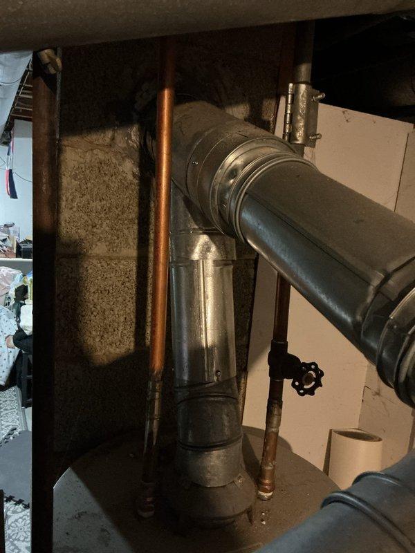 Completed full water heater installation in basement utility area. Installed new water heater unit with proper copper supply line connections, drainage configuration, and venting system integration with existing HVAC ductwork. All plumbing connections secured with appropriate fittings and shut-off valves, system tested and verified operational.