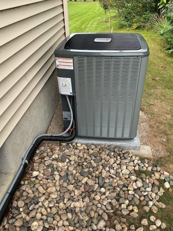 Relocated residential air conditioning condensing unit to new position along exterior foundation wall. Installed unit on concrete pad with proper clearances, ran new electrical conduit from house to unit location, and secured all connections. Verified system operation and proper drainage through existing PVC discharge line system.