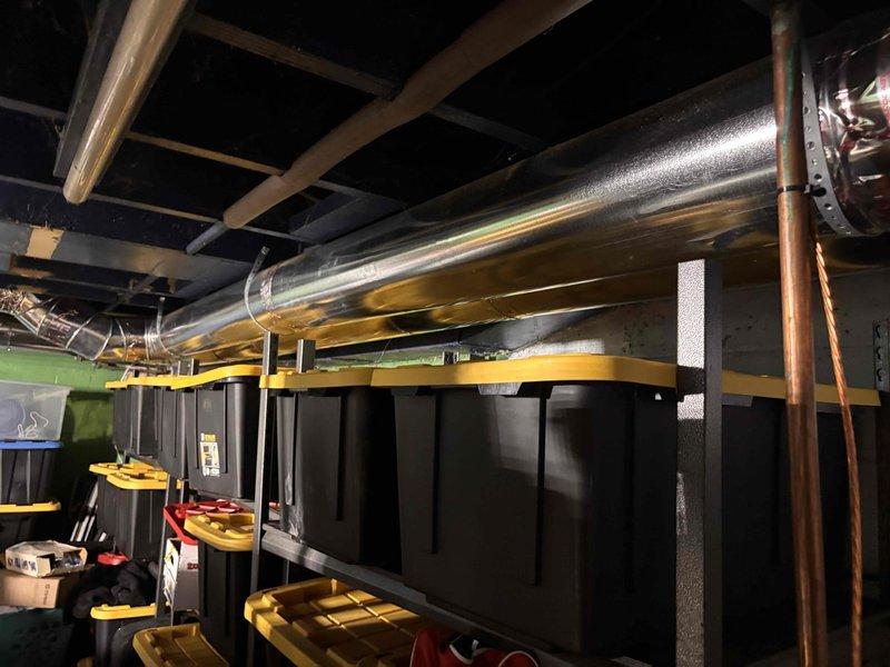 Responded to customer complaint of inconsistent airflow and temperature distribution throughout home. Performed comprehensive HVAC system inspection with focus on ductwork integrity and air delivery. Utilized digital measuring instruments to assess airflow performance, recording readings of 10.13% at various test points along the duct system. Inspected basement-level ductwork installation, including main trunk lines and distribution branches. Evaluated flexible aluminum ductwork for proper installation, support, and potential restrictions. Checked for air leakage, disconnected sections, and improper sealing at joints and connections. Assessed duct sizing and layout for adequate capacity to serve all conditioned spaces. System is 11 years old and in good overall condition.