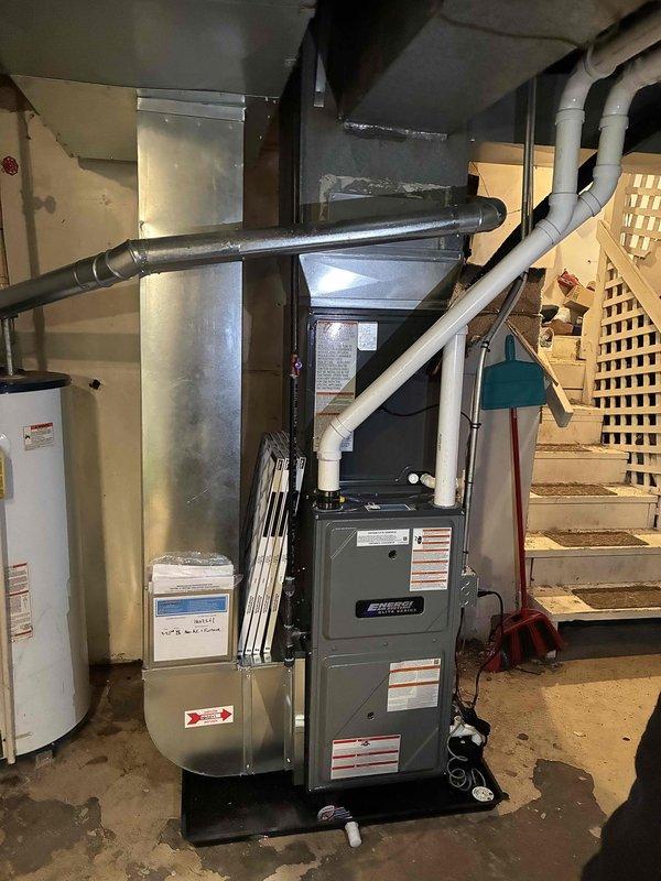 Completed full HVAC system installation including new forced-air furnace and outdoor condensing unit. Installed furnace in basement utility area with proper ductwork connections and PVC venting. Mounted outdoor AC condenser on concrete pad against building exterior with electrical conduit and junction box connection to structure. Verified all refrigerant lines, electrical connections, and drainage systems properly installed and operational. System tested and confirmed functioning within manufacturer specifications.
