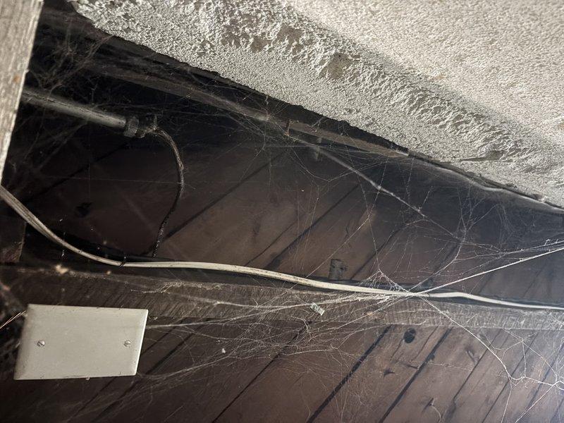 Responded to service call regarding electrical issues following recent HVAC installation, specifically intermittent lighting problems and flickering throughout the home. Upon inspection, accessed crawl space and attic areas to examine ductwork installation and electrical routing. Identified potential interference between newly installed flexible metallic ductwork and existing electrical wiring running through structural spaces. Documented conditions of installation area including ductwork placement, beam clearances, and proximity to electrical components. Photographed installation for warranty documentation and future reference. Verified proper duct insulation and support, noting accumulated debris and cobwebs in service areas indicating previous undisturbed conditions. Recommended follow-up electrical inspection to ensure proper separation between HVAC components and home electrical system to resolve lighting issues that began post-installation.