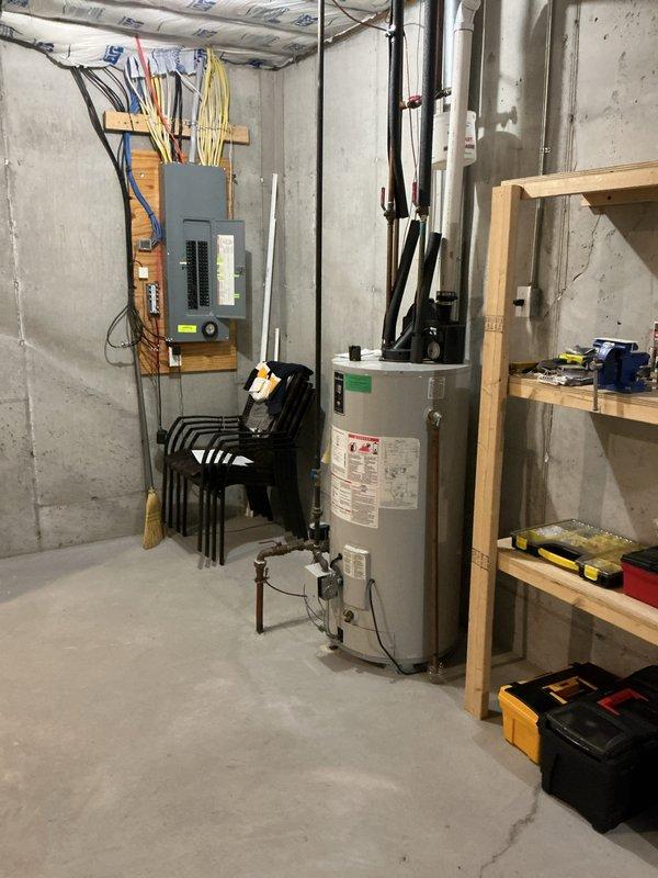 Conducted on-site evaluation for replacement of existing 50-gallon Bradford White residential water heater located in basement utility area. Assessed current installation including plumbing connections, electrical supply, venting configuration, and clearance requirements. Documented existing unit specifications, pipe configurations with copper supply lines and shutoff valves, and surrounding workspace conditions to provide accurate replacement estimate.