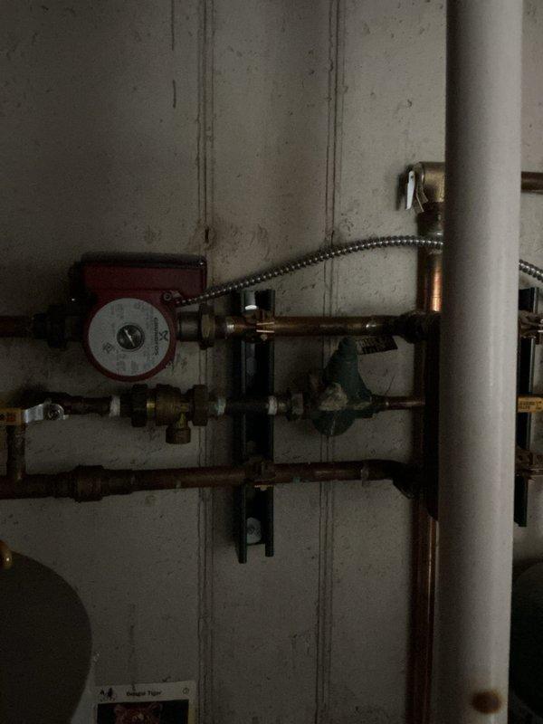 Completed annual heating maintenance inspection on 15-year-old furnace and hydronic heating system. Inspected circulator pump, copper piping network, manifold distribution system with multiple zone valves, expansion tank, and water heater connections. All components photographed and found operating within normal parameters; system ready for heating season.