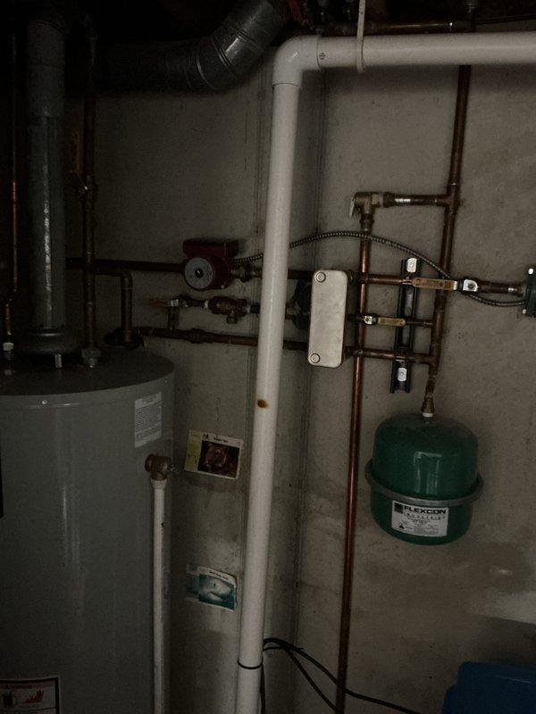 Completed annual heating maintenance inspection on 15-year-old furnace and hydronic heating system. Inspected circulator pump, copper piping network, manifold distribution system with multiple zone valves, expansion tank, and water heater connections. All components photographed and found operating within normal parameters; system ready for heating season.
