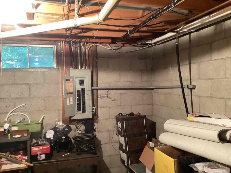 Completed generator estimate for residential property with two EnergiAir WT 11-2035 units currently installed. Evaluated exterior HVAC condenser unit mounted on concrete pad with associated electrical components including meter socket, conduit, junction boxes, and disconnect panel. Assessed basement utility room infrastructure with exposed electrical panel, PVC piping, and available space for potential generator installation. Documented existing electrical service configuration and photographed equipment locations to provide comprehensive estimate for standby generator system integration with current HVAC setup.