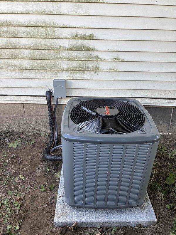 Completed full HVAC system replacement including outdoor condenser unit and indoor furnace. Removed existing equipment and installed new Emergi furnace in interior closet alcove with proper clearances and metal drip pan at base. Mounted new outdoor condensing unit on existing concrete pad against building exterior with gray electrical disconnect box and proper conduit runs. Connected refrigerant lines, electrical wiring, and ductwork to both indoor and outdoor components. Verified all connections, tested system operation, and confirmed proper airflow and cooling performance.