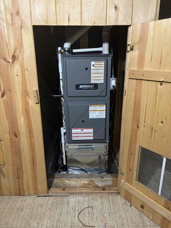 Completed full HVAC system replacement including outdoor condenser unit and indoor furnace. Removed existing equipment and installed new Emergi furnace in interior closet alcove with proper clearances and metal drip pan at base. Mounted new outdoor condensing unit on existing concrete pad against building exterior with gray electrical disconnect box and proper conduit runs. Connected refrigerant lines, electrical wiring, and ductwork to both indoor and outdoor components. Verified all connections, tested system operation, and confirmed proper airflow and cooling performance.