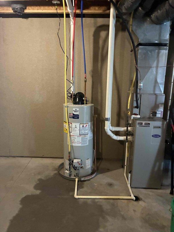 Completed installation of new residential water heater in basement utility area. Unit was properly positioned on drain pan, with all gas piping, water supply lines, and PVC venting connected according to manufacturer specifications and local code requirements. Electrical connections were made, system was tested for proper operation, and all safety features were verified functional.
