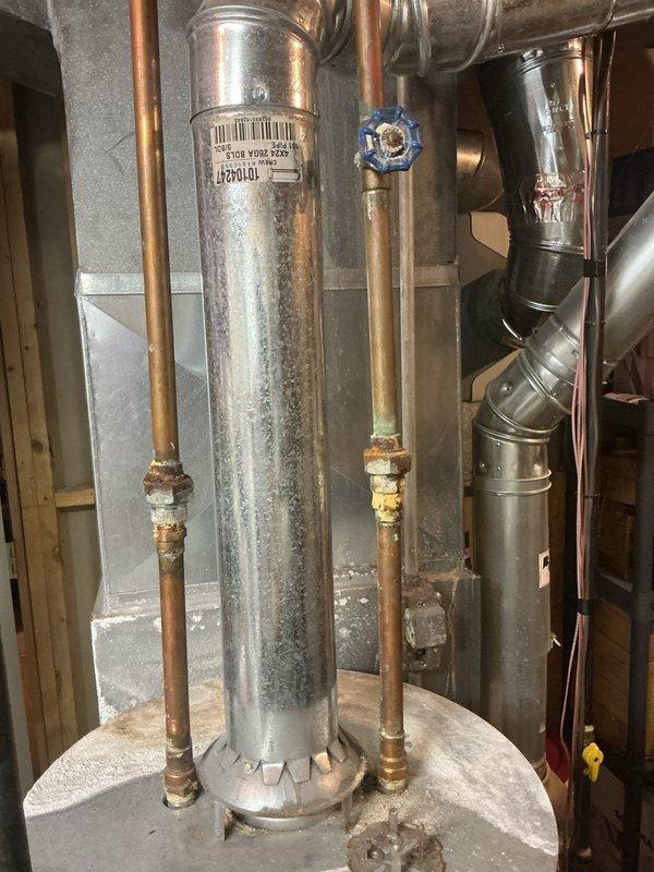 Conducted free estimate for proactive replacement of 18-year-old standard tank water heater located in basement. Unit currently functioning without leaks, malfunctions, or performance issues. Inspected existing installation including copper supply lines, brass fittings, gate valves, and venting system; documented tank condition showing age-related surface discoloration and water staining on galvanized exterior. Assessed installation area accessibility, clearances, and existing plumbing connections to provide accurate replacement specifications and pricing options for future planned upgrade.