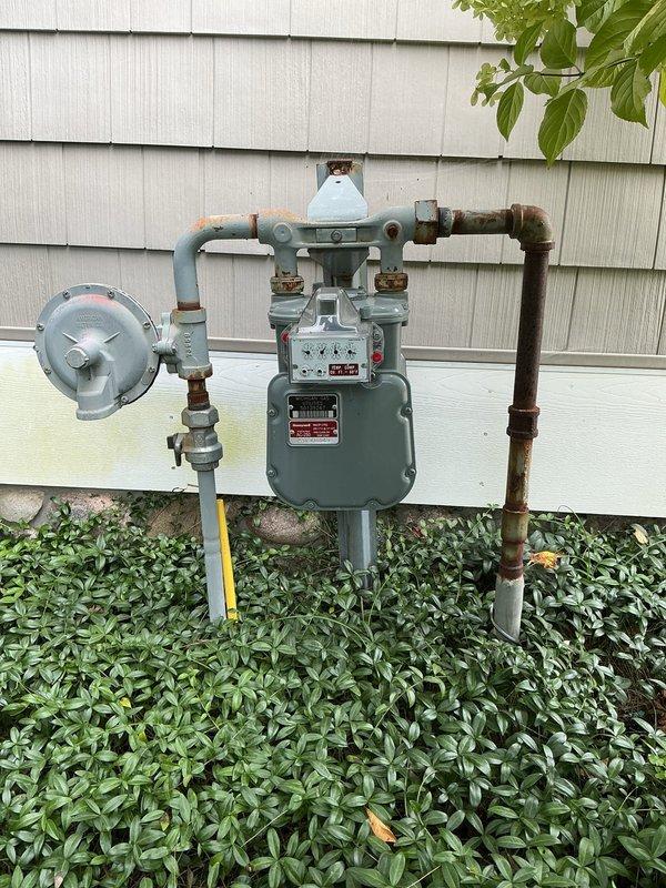 Conducted on-site evaluation for relocating existing gas line in basement area. Assessed current gas meter installation on exterior of building and inspected basement routing requirements through exposed joist space. Documented existing gas piping configuration, meter assembly with pressure regulator, and proposed pathway for line relocation. Provided estimate for gas line relocation work.