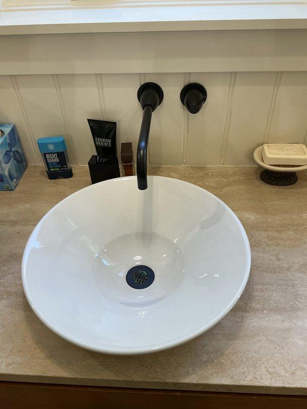 Responded to report of broken pipe beneath bathroom vanity sink. Upon arrival, inspected plumbing connections under vessel sink and determined P-trap and drain assembly were secure with no active leaks detected. Chrome P-trap showed proper installation with tight connections at slip joints. Wall-mounted faucet and drain system functioning normally with no visible water damage to cabinet interior or surrounding areas. Verified all plumbing fixtures operational and leak-free at time of inspection.