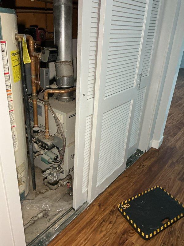 Performed comprehensive inspection of 27-year-old Reliant water heater and associated plumbing systems. Documented multiple safety and code compliance concerns including significant corrosion around water supply connections and heat source area, absence of required sediment trap on gas line, and improper shared exhaust venting configuration between water heater and boiler system. Photographed all deficiencies for client review and future remediation planning.