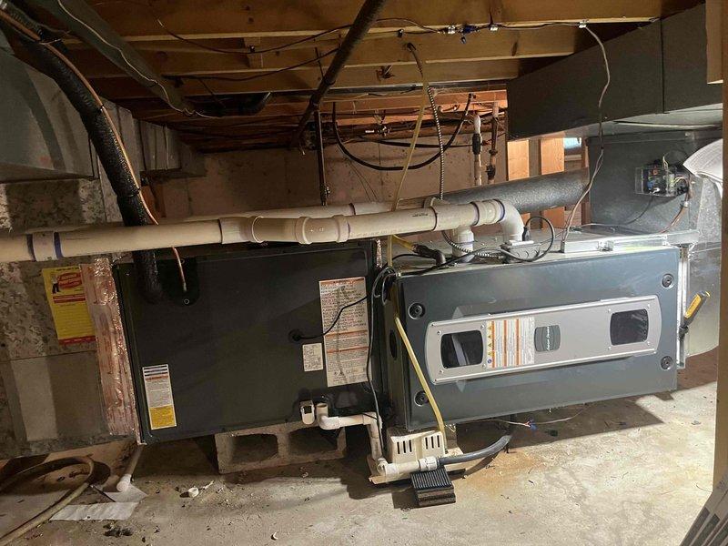 Completed full air conditioning system replacement including outdoor condenser unit and indoor air handler. Installed new condenser on exterior concrete pad with proper electrical disconnect box and refrigerant line connections. Mounted new air handler in basement mechanical room alongside existing furnace, with all necessary condensate drainage piping and electrical connections properly configured per manufacturer specifications. System tested and verified operational.