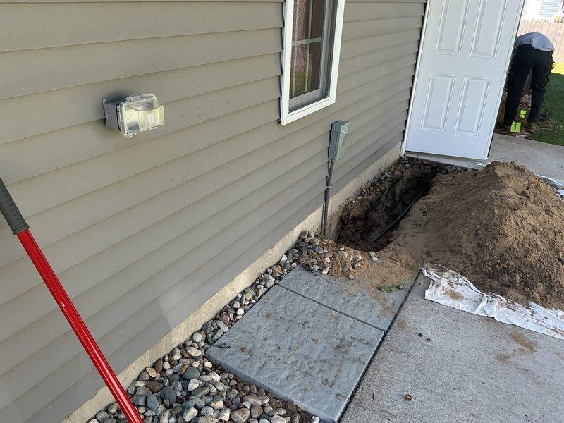 Completed excavation and utility access work at residential foundation. Excavated trench adjacent to building foundation to expose and access underground utility infrastructure, including gas meter and associated PVC piping systems. Performed necessary repairs and adjustments to exterior utility connections and restored work area with proper backfill and decorative river rock landscaping upon completion.