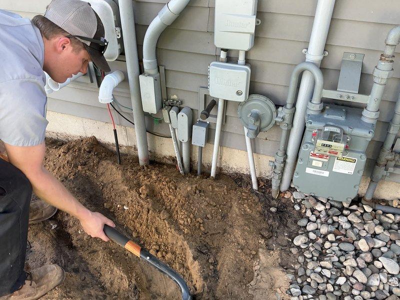 Completed excavation and utility access work at residential foundation. Excavated trench adjacent to building foundation to expose and access underground utility infrastructure, including gas meter and associated PVC piping systems. Performed necessary repairs and adjustments to exterior utility connections and restored work area with proper backfill and decorative river rock landscaping upon completion.