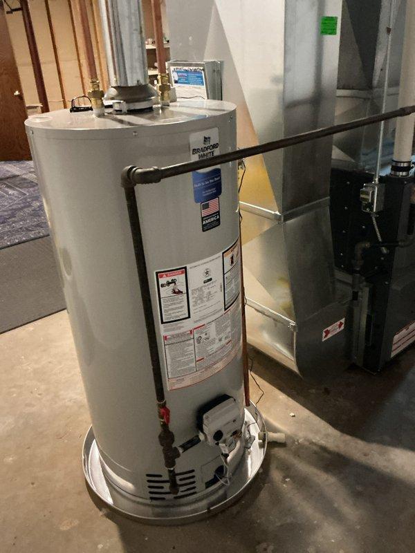Completed installation of 40-gallon natural gas water heater in residential basement utility area. Installed new Bradford White unit with proper copper supply line connections, pressure relief valve, and gas line hookup, ensuring all plumbing and gas connections meet code requirements. Unit tested and verified operational with no leaks detected.